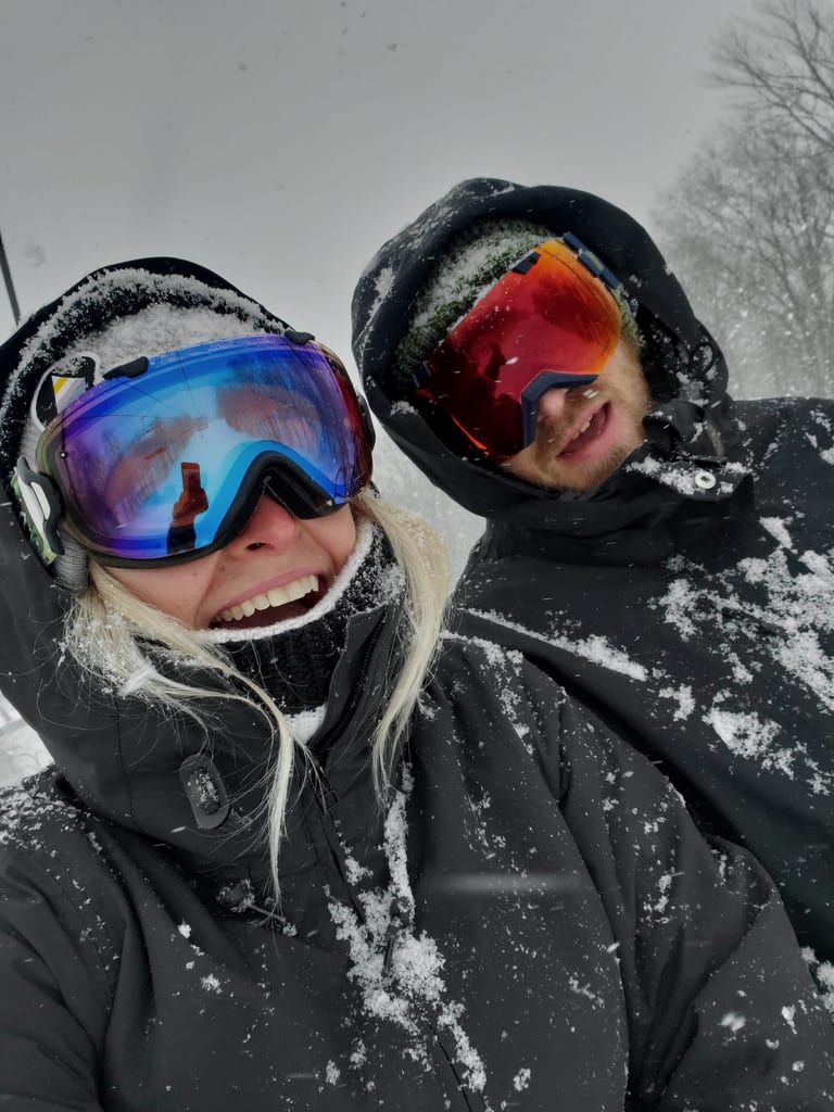 Ashley and Ryan in ski goggles, covered in snow